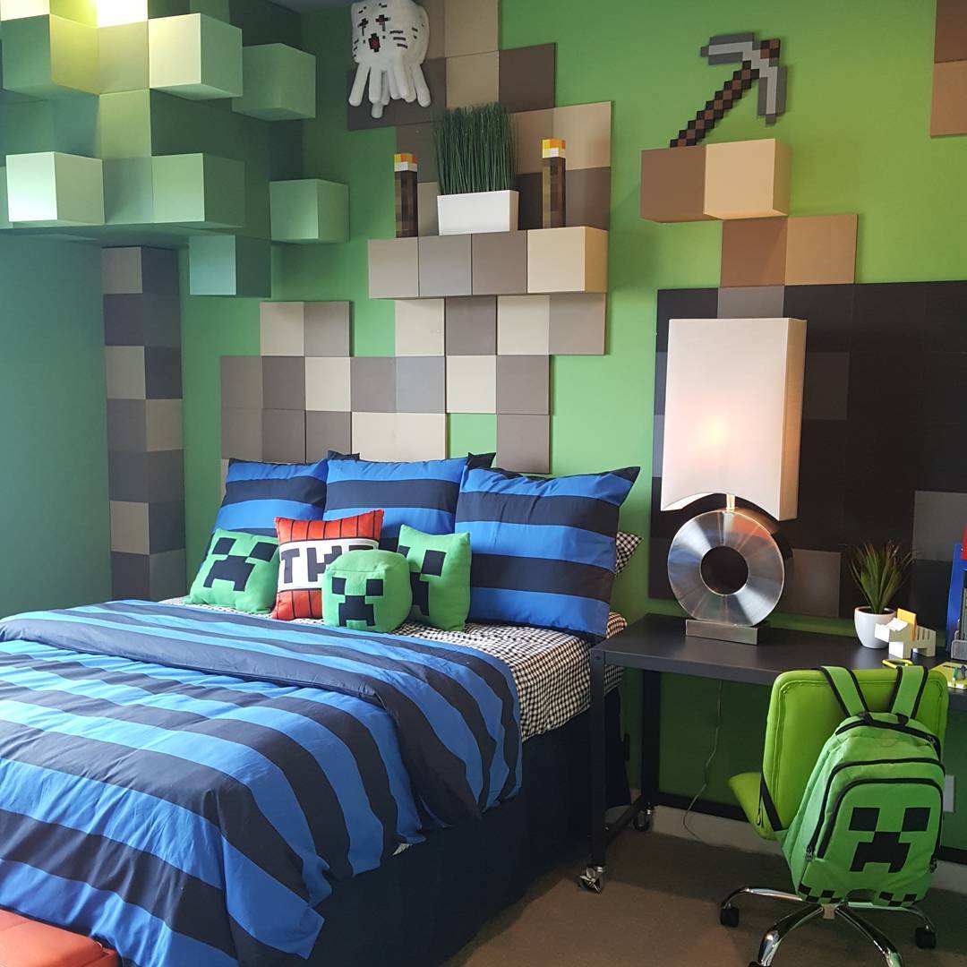 Minecraft bedroom with 3D pixel block headboard wall feature in green gray and tan with Ghast plush pickaxe wall art and striped blue bedding