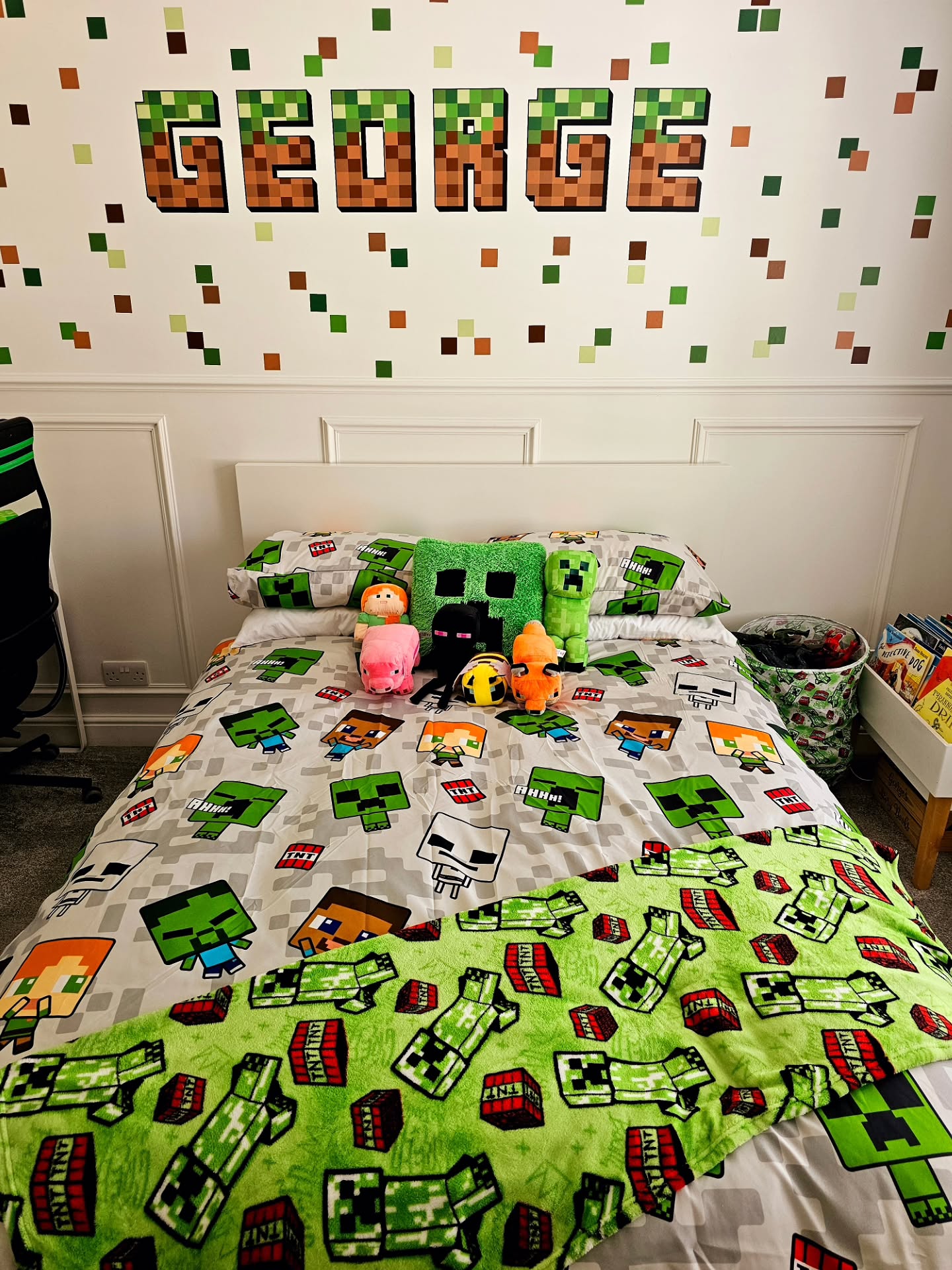 Minecraft themed boys bedroom with pixel block name decal spelling GEORGE above bed with Creeper plushies and green TNT patterned blanket