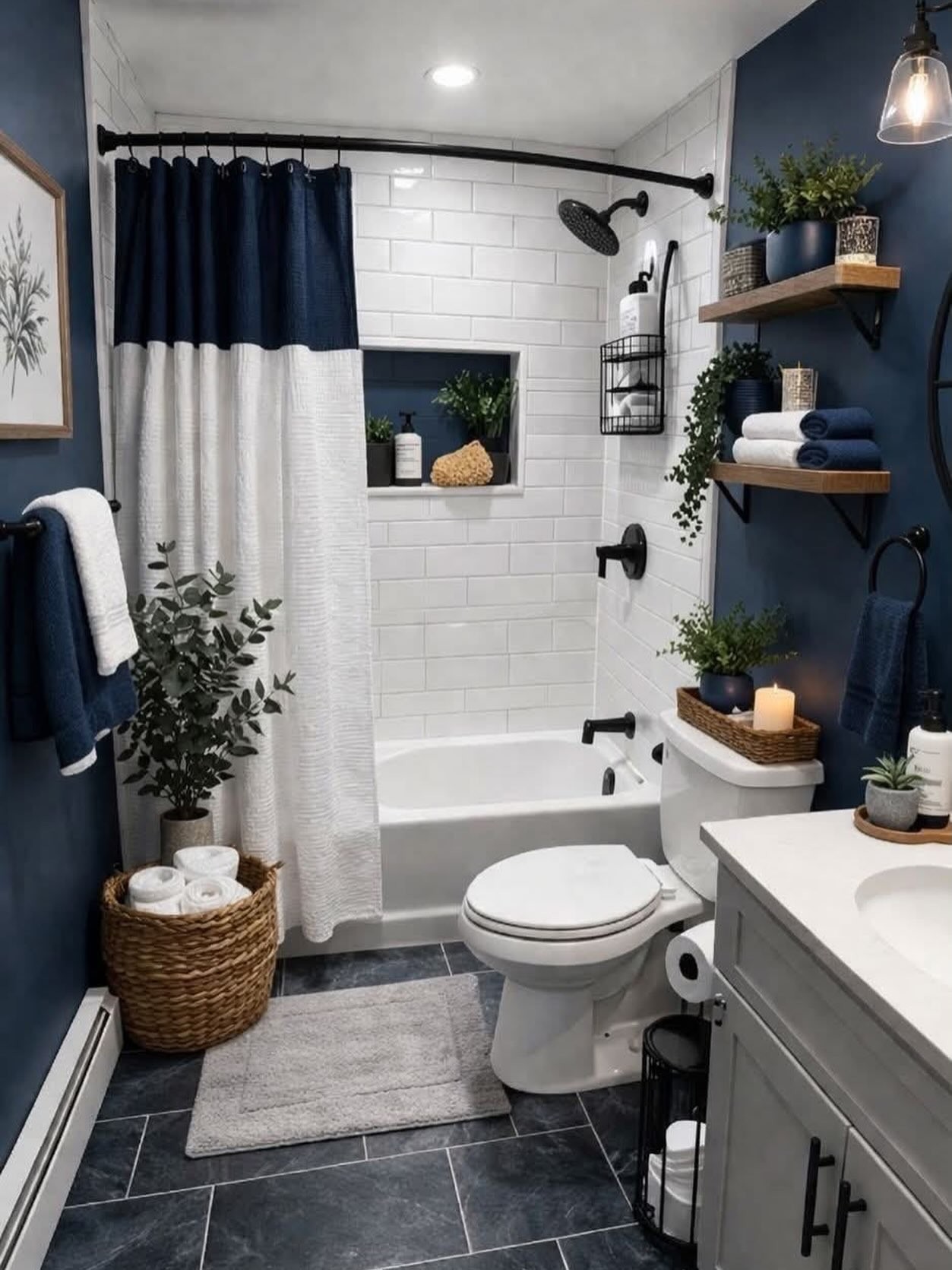 Deep navy blue painted bathroom walls with a white subway tile shower, open stained wood shelves with towels and plants, black fixtures, slate tile floor, and a woven basket of rolled towels