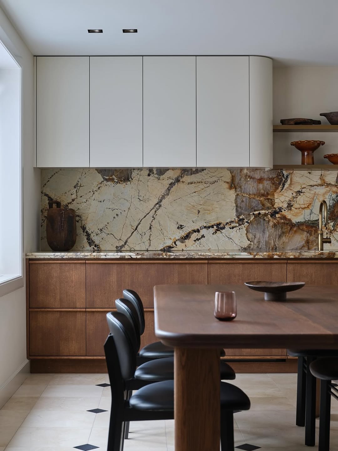 Patagonia quartzite backsplash in cream, rust and black veining running over walnut flat panel lower cabinets with white rounded upper cabinets