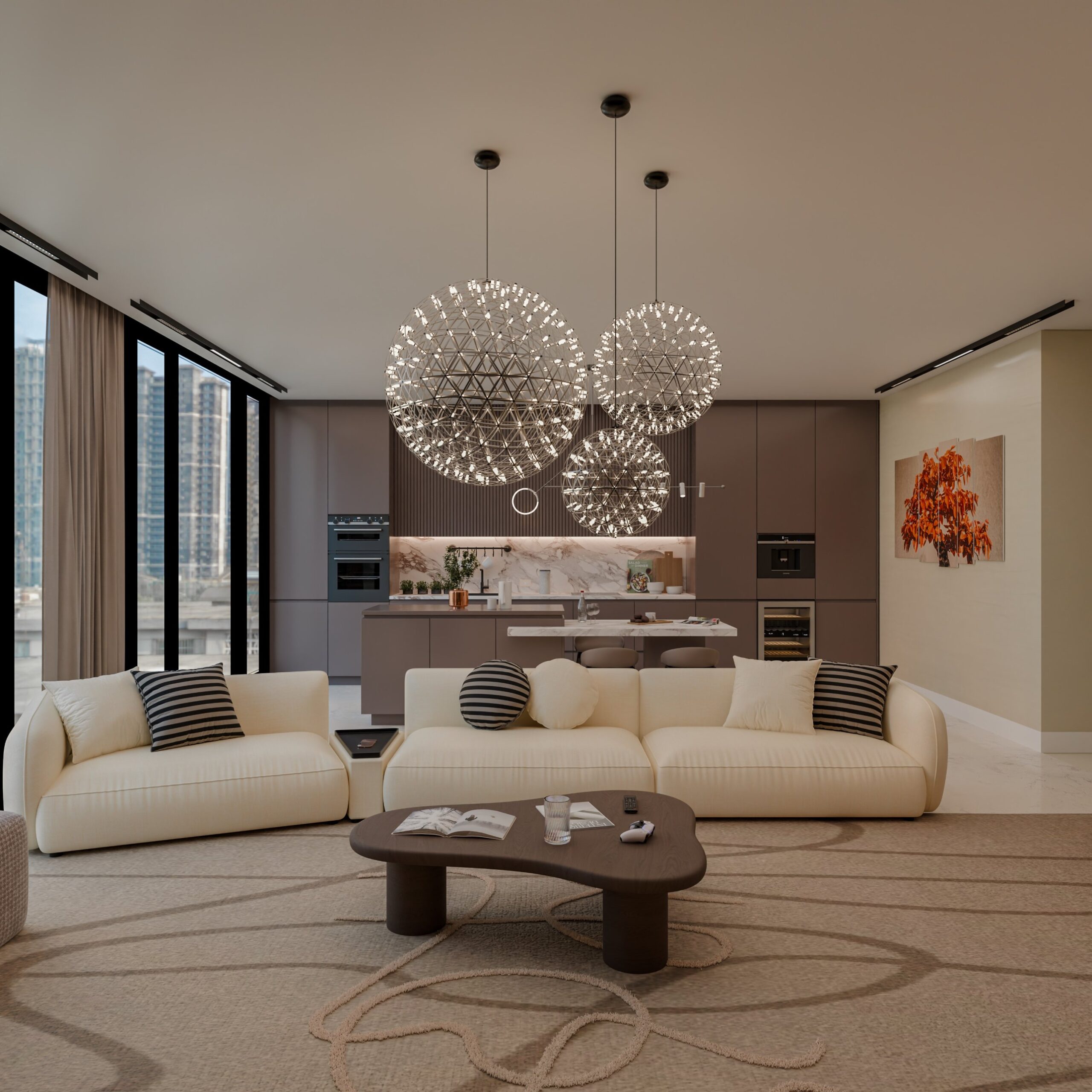 Two cream curved sofas arranged in a conversation setup with black-and-white striped pillows and a dark wood cloud-shaped coffee table, under three oversized silver sphere wire chandeliers, with an open-plan modern kitchen featuring taupe slab cabinets and a white marble waterfall island visible behind, and floor-to-ceiling windows showing a city skyline on the left