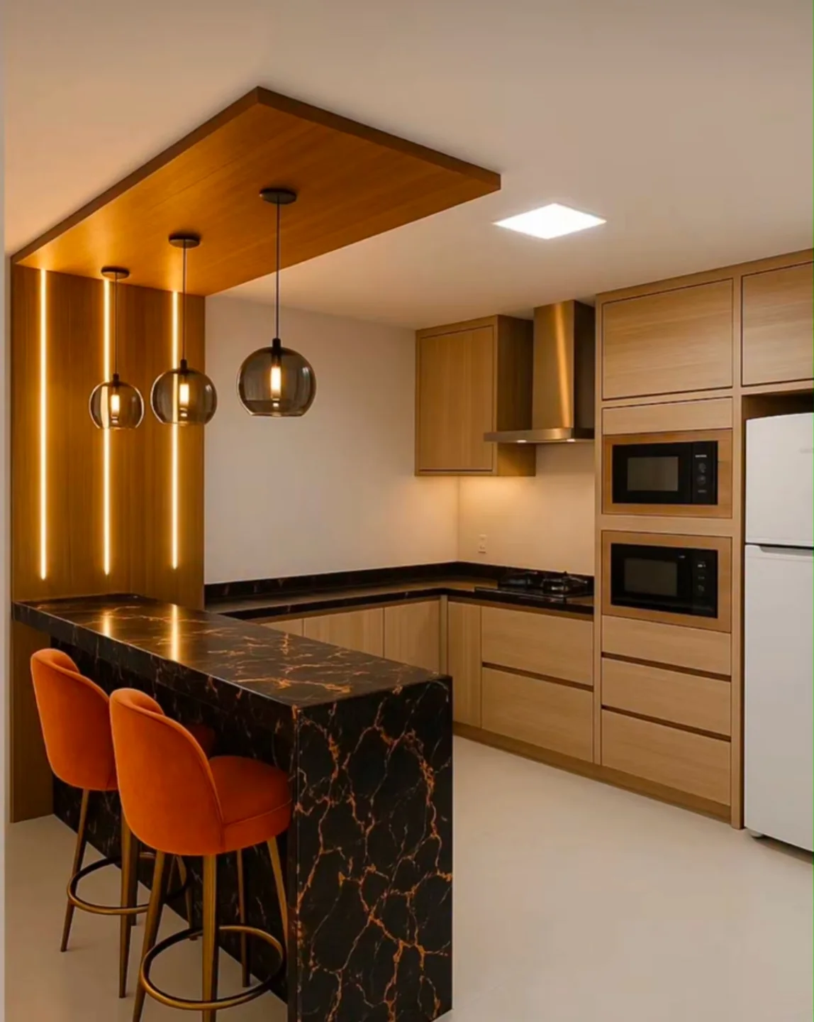 Wood ceiling panel dropped above a black marble peninsula with gold veining, two burnt orange velvet bar stools, three pendant lights, and warm vertical LED strips on the back wall